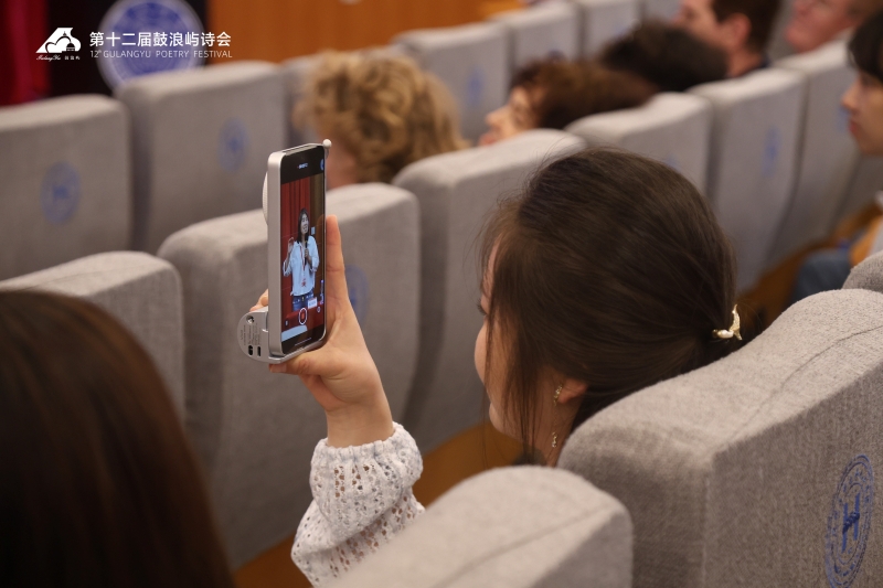 有同学正用手机记录裴爱民的分享。人民视频供图